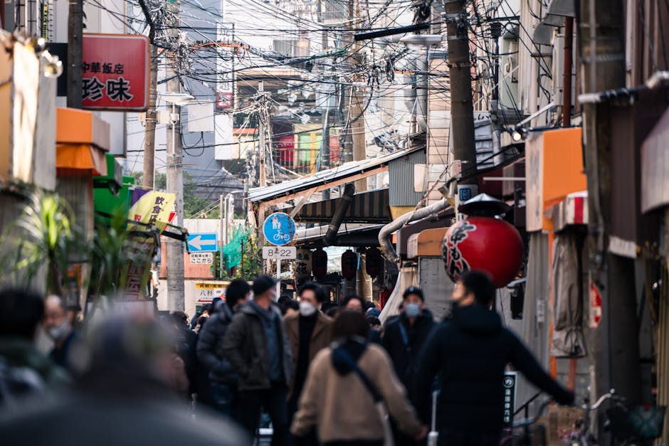 Experience the vibrant life of Dotonbori, Osaka with bustling street and tourists.