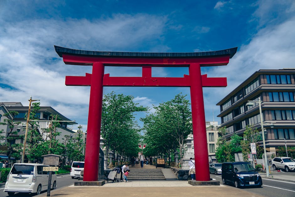 Scenic view of a red torii gate in Kamakura, Japan with city streets and blue sky