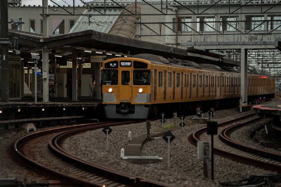 Yellow train arrives at Saitama Station in Japan, showcasing urban transport.