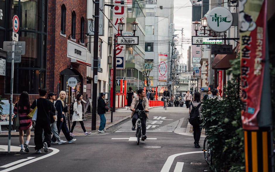 A vibrant street in Osaka featuring pedestrians and cyclists amidst urban architecture.
