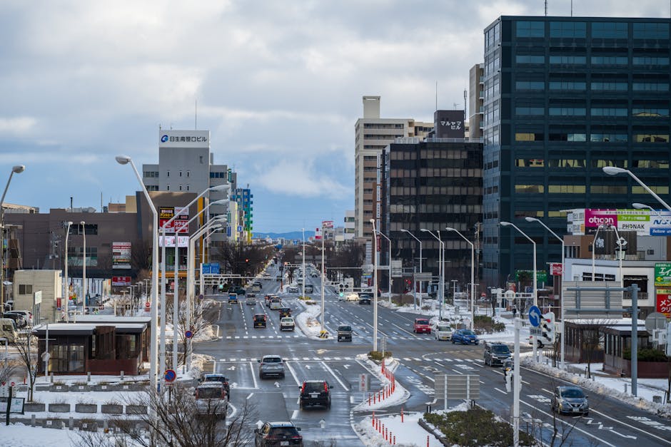 A bustling city street in winter with cars and buildings lined with snow.