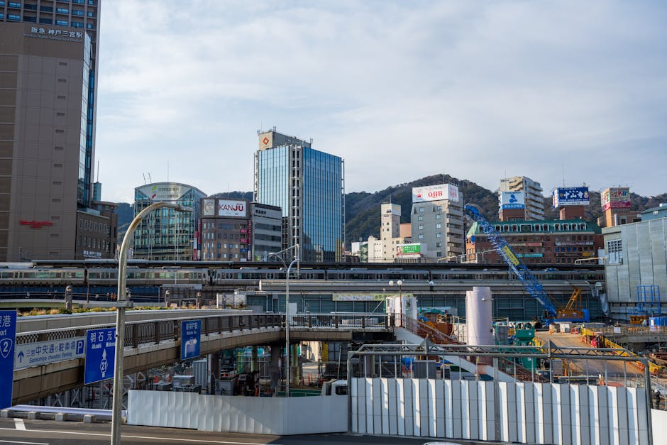 View of Sannomiya Station with skyscrapers and construction work in Kobe, Japan.