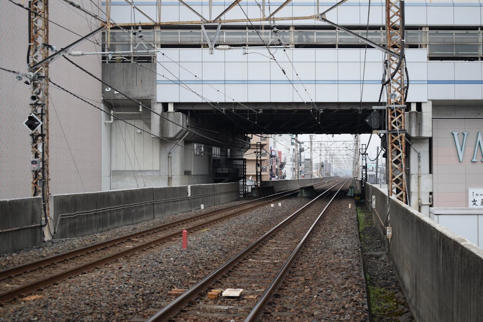 A view of train tracks under a modern bridge in Saitama, Japan, highlighting urban transit infrastructure.