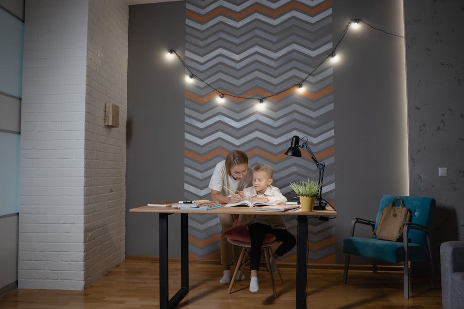 A mother assists her young son with homework at a desk in a cozy indoor setting.