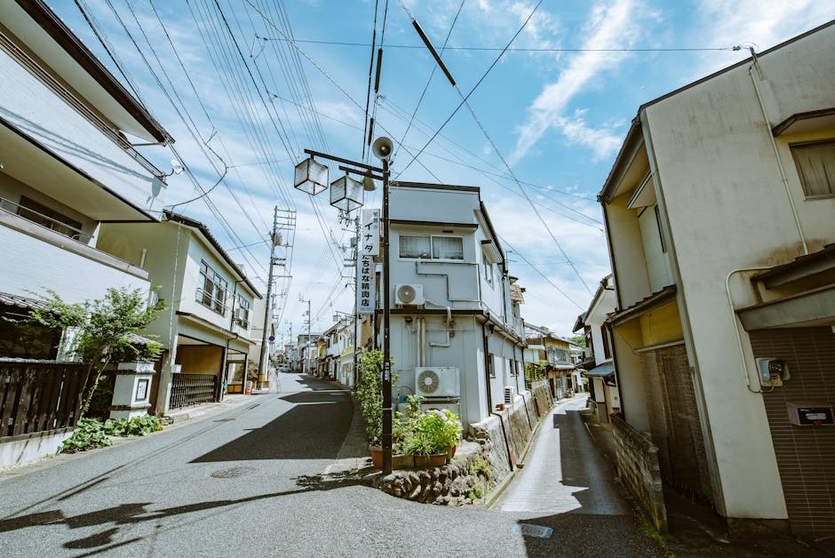 Explore a picturesque narrow street lined with traditional houses under a clear blue sky.