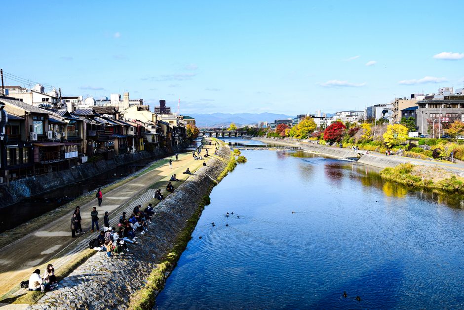 Beautiful scenery of Kamo River with cityscape and autumn foliage in Kyoto, Japan.