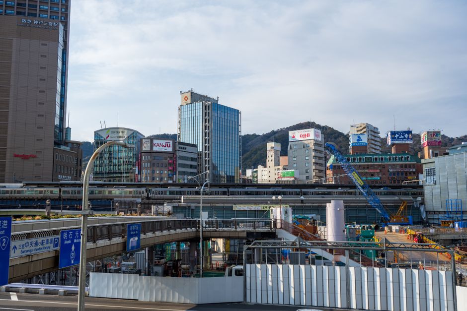 View of Sannomiya Station with skyscrapers and construction work in Kobe, Japan.