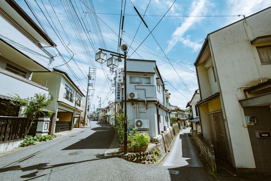 Explore a picturesque narrow street lined with traditional houses under a clear blue sky.